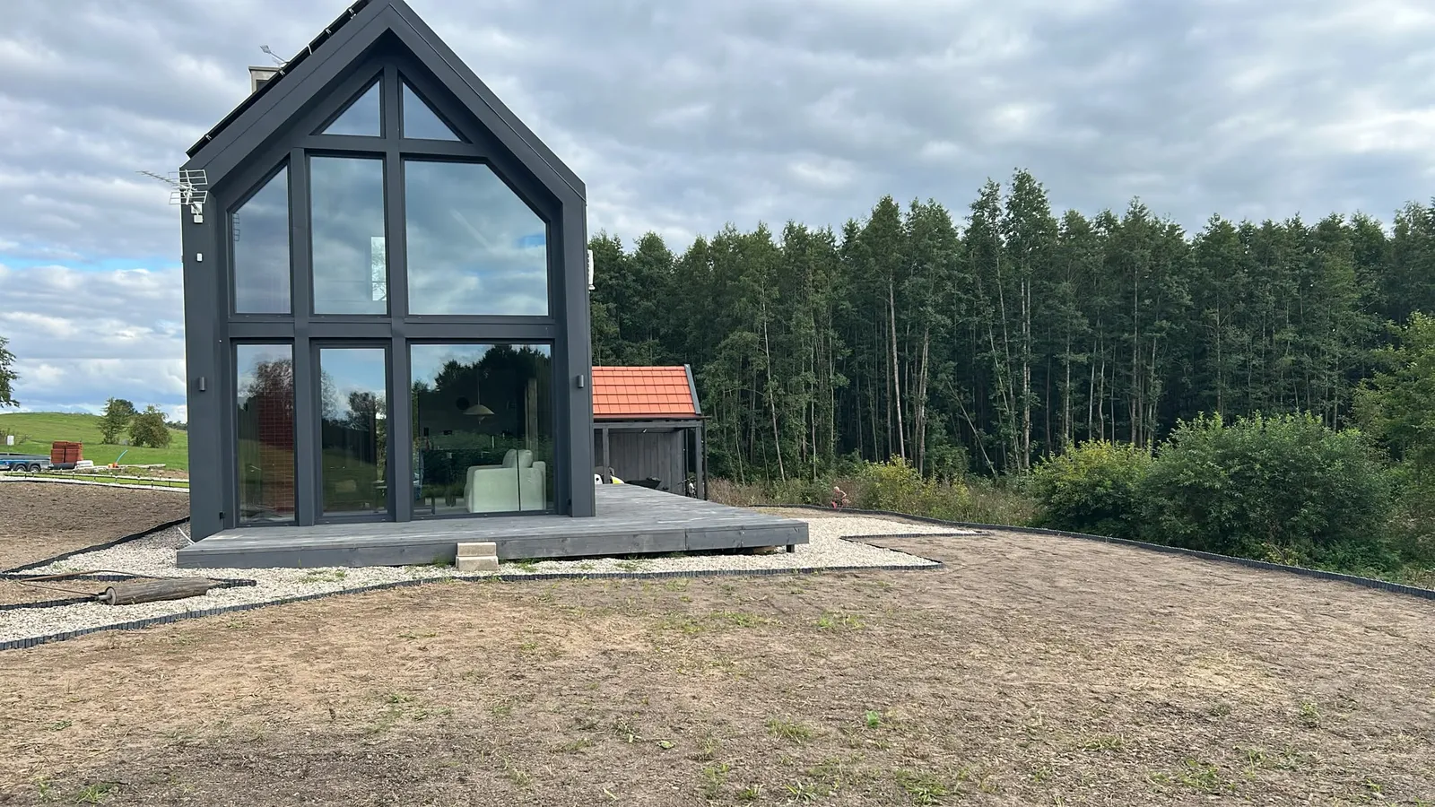 Domek Brzoza z przeszkloną ścianą szczytową na tle lasu